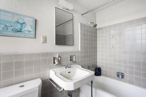 y baño con lavabo, espejo y bañera. en Spacious 2 Bedroom 2 Bathroom Unit Great Location en Los Ángeles