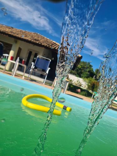 een zwembad met gele noedels in het water bij Casa na Ilha de Mar Grande in Vera Cruz de Itaparica