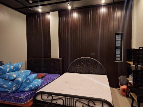 een slaapkamer met een bed met blauwe kussens erop bij Bora House in Bago