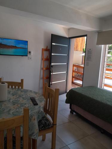 1 dormitorio con mesa, 1 cama y balcón en Rincon de las sierras en Villa Carlos Paz