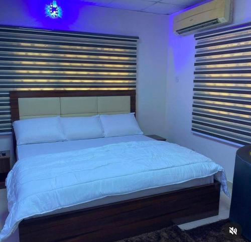 ein Schlafzimmer mit einem großen Bett mit weißer Bettwäsche in der Unterkunft Optimum Residence in Lagos