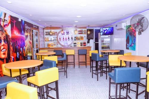 un restaurante con mesas y sillas y un bar en Optimum Residence, en Lagos