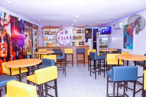 a restaurant with tables and chairs and a bar at Optimum Residence in Lagos