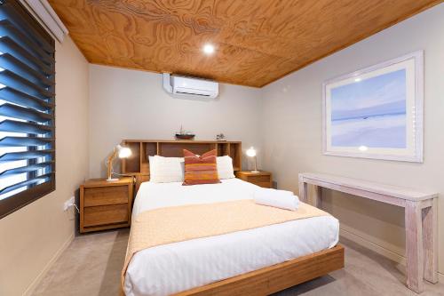 Un dormitorio con una cama grande y una ventana. en Driftwood Shores, en Forster