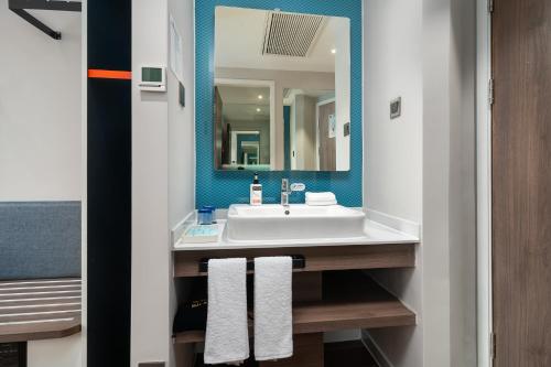 a bathroom with a white sink and a mirror at Holiday Inn Express Xiamen Lushan -Shopping Center by IHG in Xiamen