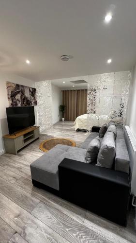 un soggiorno con divano e TV a schermo piatto di London charming bedroom flat a Londra