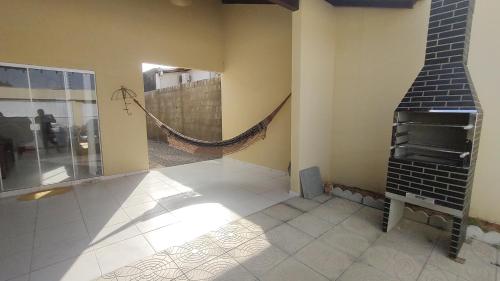 a living room with a brick fireplace and a hammock at Casa Caminho da Alvorada in Parnaíba