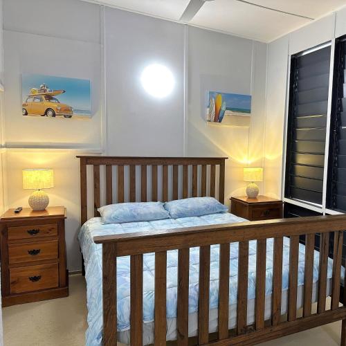 a bedroom with a wooden bed and two night stands at Unit 1 Golden Sands Retreat in Wagait Beach