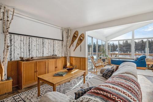 a living room with a couch and a table at Stunning Secluded Richibucto River Waterfront Cottage with Unparallel Privacy in Rexton