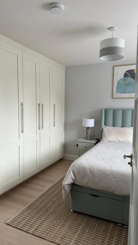 a bedroom with a bed with white cabinets and a rug at Double bedroom with private bathroom close to city center in Cork
