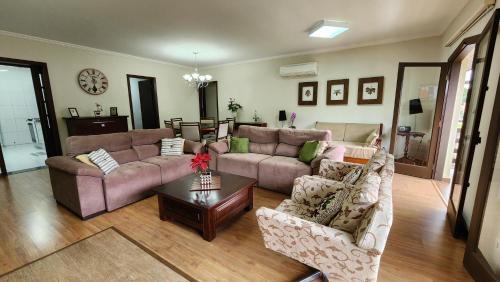 a living room with two couches and a table at Apto no centro turístico Capivari (150m do Baden) in Campos do Jordão