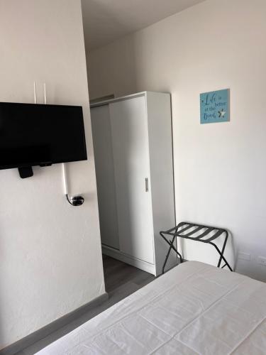 a bedroom with a bed and a television on a wall at EMY HOUSE in La Laguna
