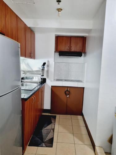 uma pequena cozinha com um lavatório e um frigorífico em Newport's STAR em Manila