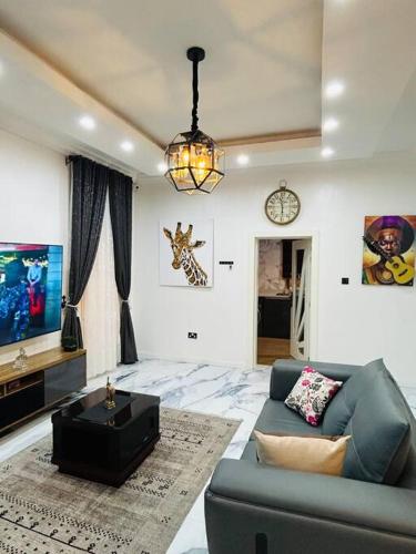 sala de estar con sofá y TV en Not Like The Rest of ‘Em! en Lagos