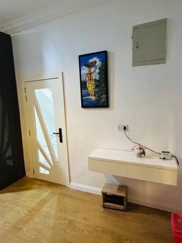 um quarto com uma parede branca com um lavatório e uma porta em Not Like The Rest of ‘Em! em Lagos