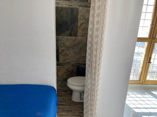 baño con aseo y pared de piedra en Casa Isla Delfín, en Lo de Marcos