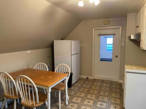 uma cozinha com uma mesa e cadeiras e um frigorífico em Appartement centre Lévis em Lévis