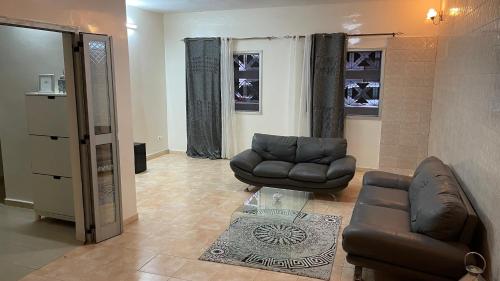 uma sala de estar com um sofá e uma cadeira em Villa L6 em Dakar