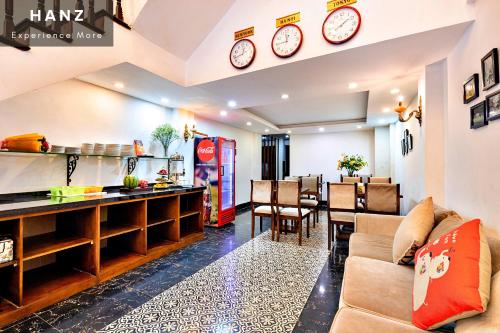- un salon avec un canapé et des horloges murales dans l'établissement HANZ Ami Hotel, à Hanoï