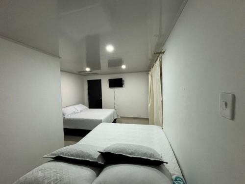 Kleines Zimmer mit 2 Betten und einem TV in der Unterkunft HOTEL TUNJA ALEJANDRIA in Tunja