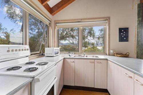 a kitchen with a stove and a sink at Snowgums on the Lake in Jindabyne