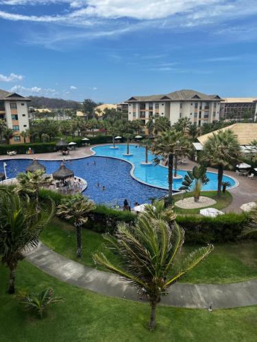 a large swimming pool in a resort with palm trees at Cumbuco Ap VGSUN 402 in Cumbuco