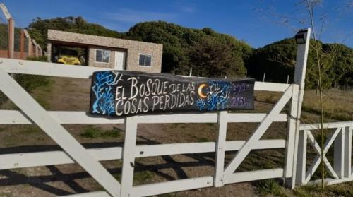 Una cerca blanca con un cartel. en Alquiler playa Quequén, Necochea Buenos Aires en Quequén