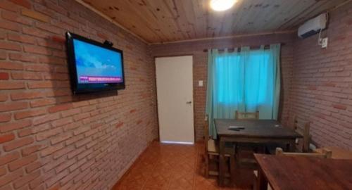 Habitación con TV en una pared de ladrillo en Alquiler playa Quequén, Necochea Buenos Aires en Quequén