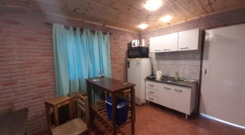 cocina con nevera y mesa en una habitación en Alquiler playa Quequén, Necochea Buenos Aires en Quequén