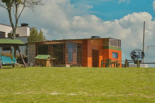 a building in a park with a grass field at Hotel Reserva Campestre LA CABAÑA GLAMPING in Duitama