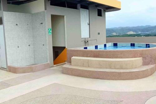 un edificio con una piscina con escaleras y un edificio en EDIFICIO LOS DELFINES Walk to the Beach en Atacames