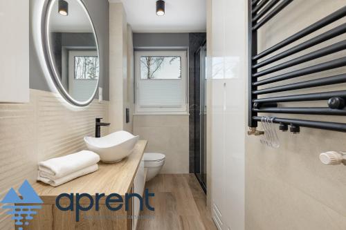 a bathroom with a sink and a toilet and a mirror at Apartament Sunset - Pobierowo Baltic Apartments - Aprent in Pobierowo