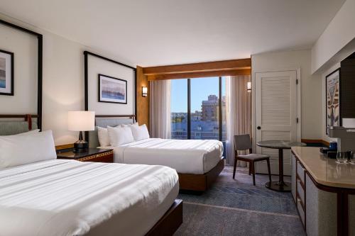 a hotel room with two beds and a view of a city at Merriweather Lakehouse Hotel, Autograph Collection in Columbia