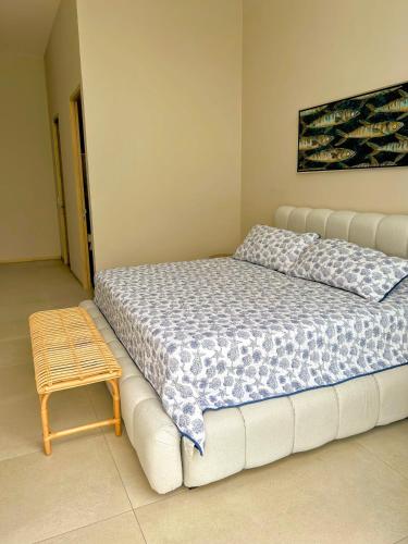 a bedroom with a bed and a wooden stool at Gorgeous Bucerias Penthouse TAYAU in Bucerías