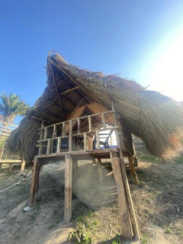 a hut with a thatched roof on a beach at Freeland Eco Hostel in Santa Marta