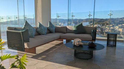 a living room with a couch and a table at Gorgeous Bucerias Penthouse TAYAU in Bucerías