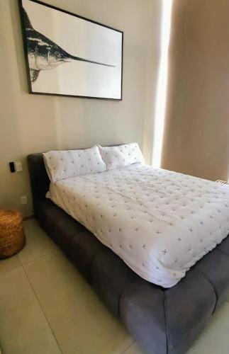 a bed with a white comforter in a bedroom at Gorgeous Bucerias Penthouse TAYAU in Bucerías