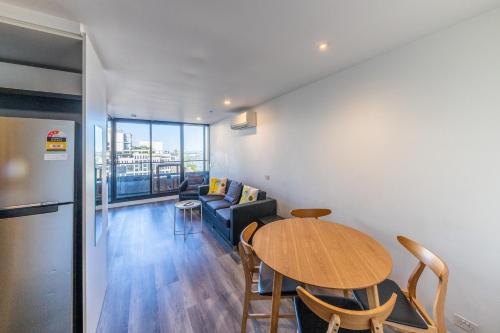 a living room with a table and a couch at Aura2107, CBD Entire 2 Bedroom Apartment with Balcony and Stunning Yarra River Views in Melbourne