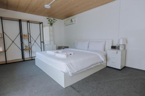 Un dormitorio blanco con una gran cama blanca. en Blue Carina Hotel - SHA Plus en Phuket