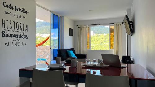 a living room with a table with a laptop on it at Apartahotel La Terraza - San Gil in San Gil