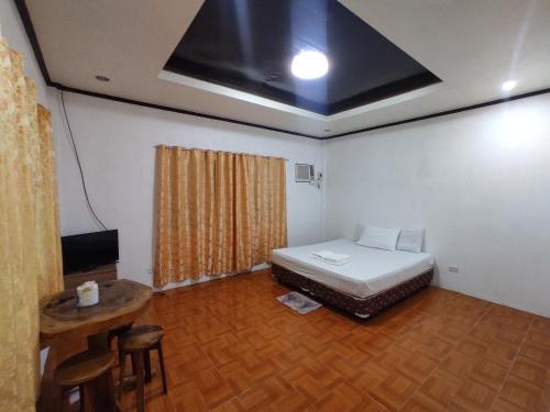 Zimmer mit einem Bett und einem TV. in der Unterkunft Apoestin homestay in Siquijor