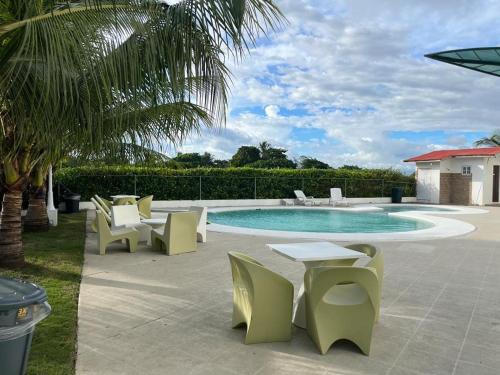 大衛的住宿－Playa La Barqueta , Las Olas Tower Front，一个带椅子的庭院和一个带桌椅的游泳池