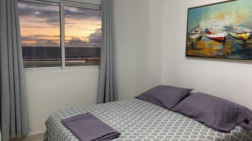 大衛的住宿－Playa La Barqueta , Las Olas Tower Front，卧室配有一张床,墙上挂有绘画作品