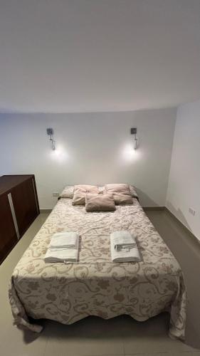 1 dormitorio con 1 cama grande y toallas. en Solares, Departamento zona centro en La Rioja