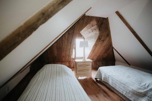 um quarto no sótão com 2 camas e um candeeiro em Le Patrimonial em Sainte-Agathe-des-Monts