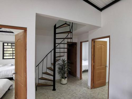 a room with a spiral staircase and a bedroom at Hermosa finca a 5 minutos aeropuerto in Guarne