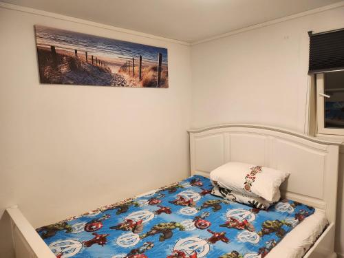 uma cama num quarto com uma fotografia na parede em Fjordclaw SNM- adjoining the Bergen city & Nature em Bergen