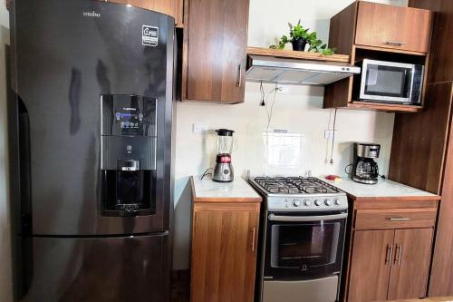 een keuken met een roestvrijstalen koelkast en een fornuis bij Joya de Santa Ana, Apartamento privado completo in Santa Ana
