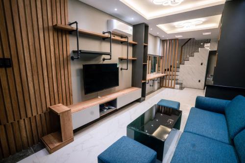 a living room with a tv and blue chairs at Cozy house near Pink Church in Ho Chi Minh City