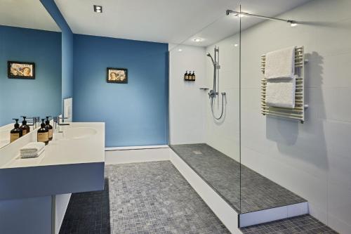 a bathroom with a glass shower and a sink at the Deutz, a Tribute Portfolio Hotel in Cologne